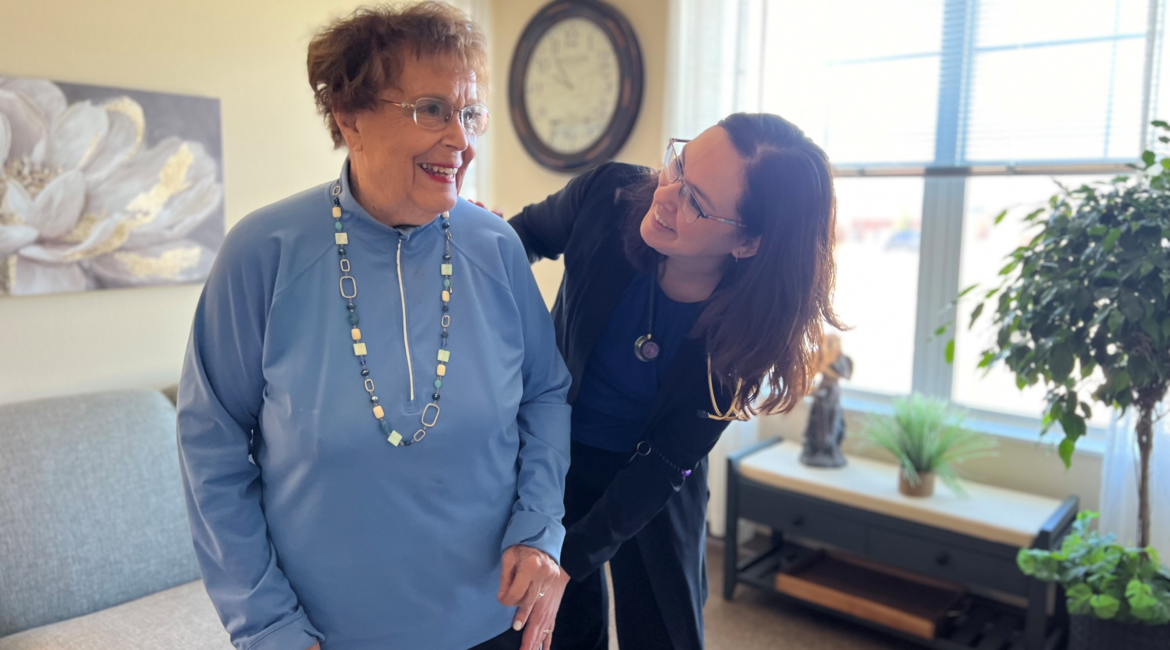 Senior female standing next to female clinician.