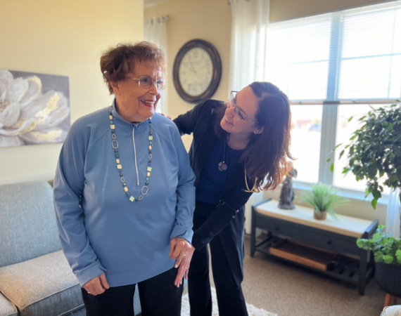 Senior female standing next to female clinician.