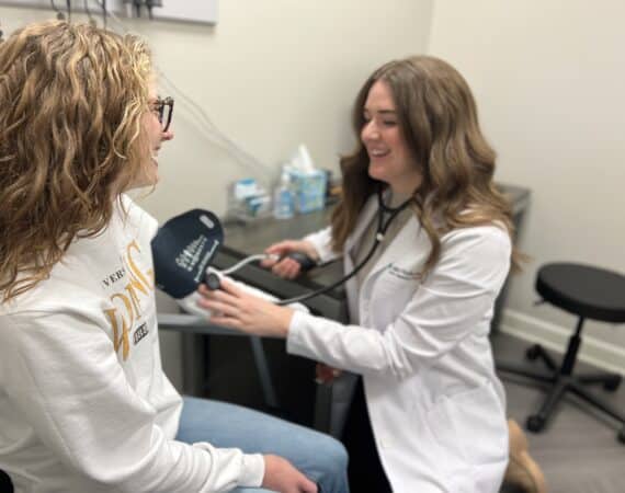 Female clinician testing blood pressure of female patient